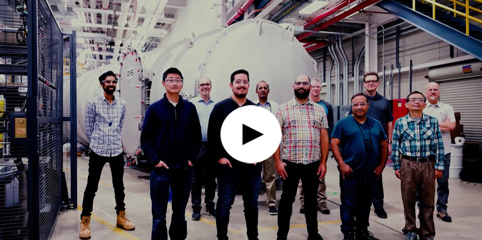 The team behind the assembly of the Grand Tube stands in front of the finished enclosure at beamline 9-ID of the Advanced Photon Source. 

