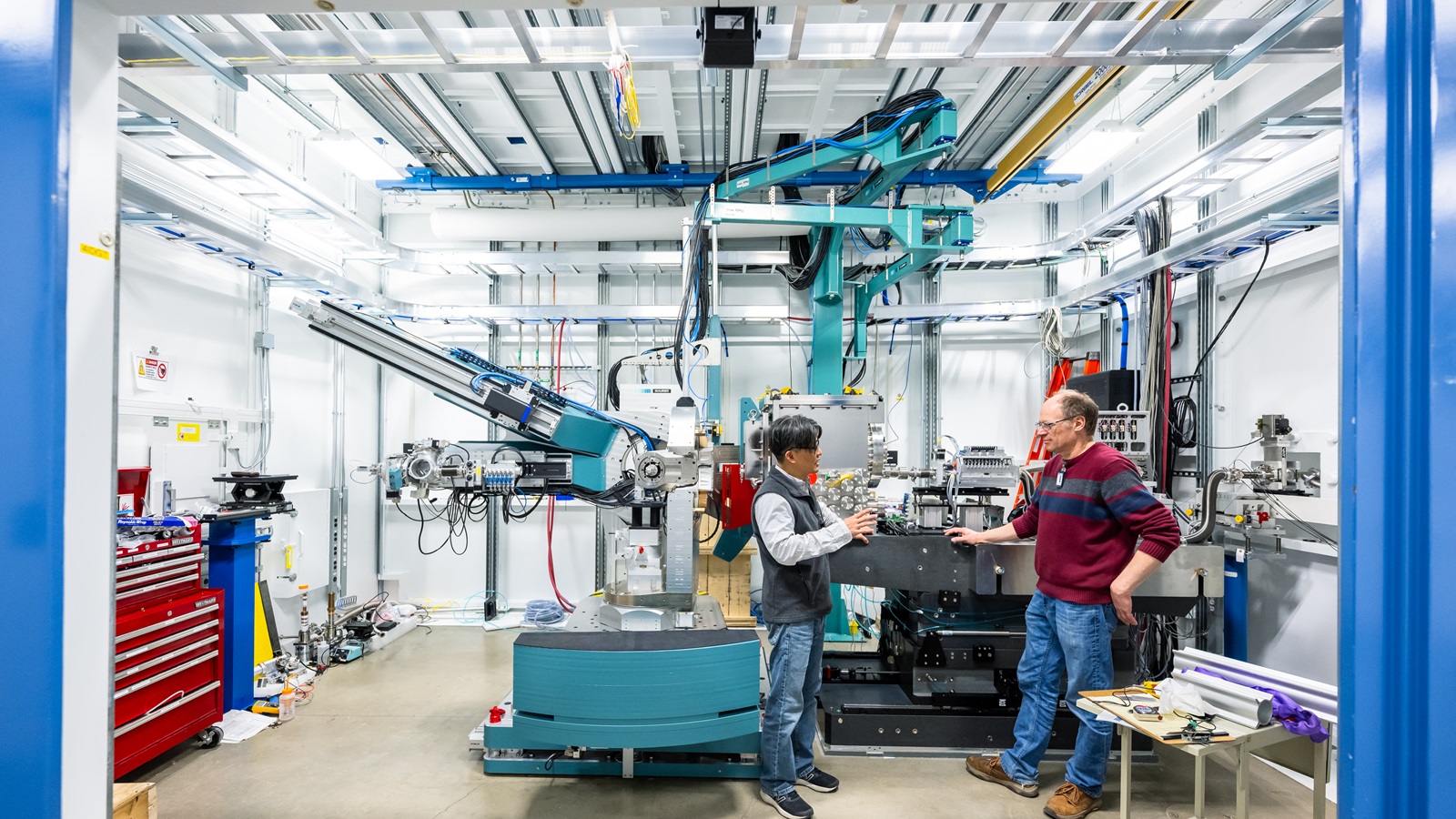 Argonne physicists Youngseong Choi, left, and Jeorg Strempfer with the new instrument installed for the POLAR feature beamline at the APS. (Image by Mark Lopez/Argonne National Laboratory.) Two men near a complicated-looking scientific machine colored silver and green.