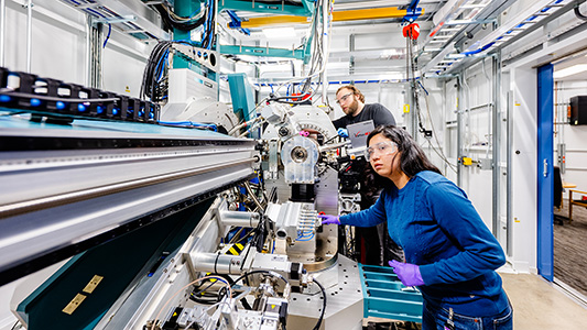 A pair of young scientists working on a machine.