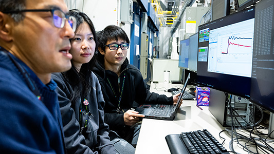 Three scientists looking at a computer.