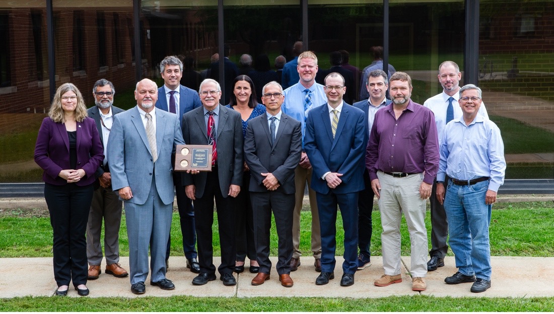 Group photo of award winners posing with the Defense Programs Award of Excellence.