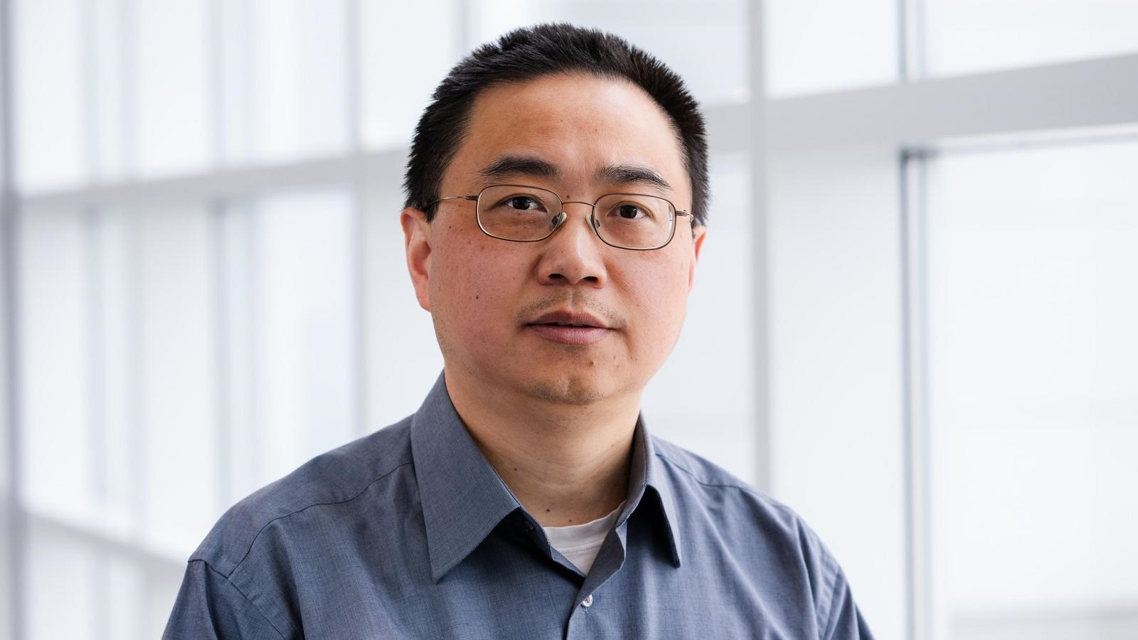 Photo of a man wearing glasses and a collared shirt.