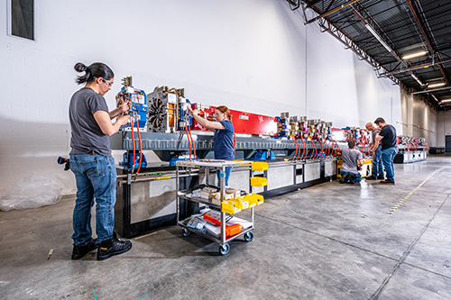 Members of the APS Upgrade team work on the first fully assembled sector of the new electron storage ring at the heart of the upgraded APS. The 1,321 magnets that make up the new storage ring will be assembled into 200 modules, and those modules assembled into 40 full sectors for installation at the APS. (Image by Jason Creps, Argonne National Laboratory.)