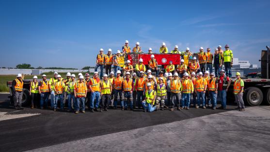 The final girder of magnets to be removed from the Advanced Photon Source facility, surrounded by the team of contractors who completed the removal. Image by J.J. Starr, Argonne National Laboratory.