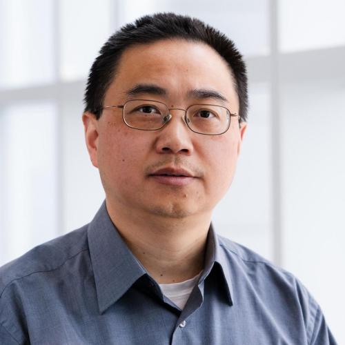 Photo of a man wearing glasses and a collared shirt.